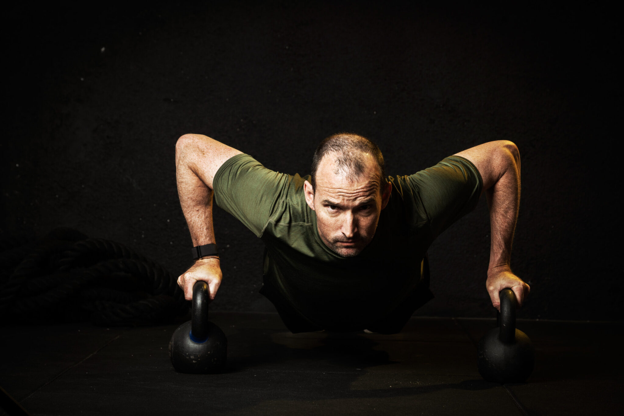 Ronnie Schildknecht doing push-ups on kettlebells – training mental strength in triathlon