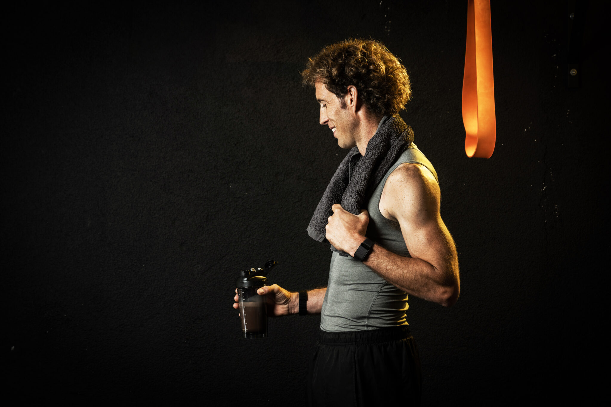Athlete with towel and protein shake after training, highlighting Protein Timing Over 40.