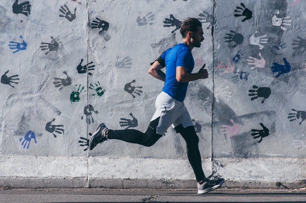 Läufer vor einer grafischen Wand – Cardio als Teil von Abnehmen mit System.