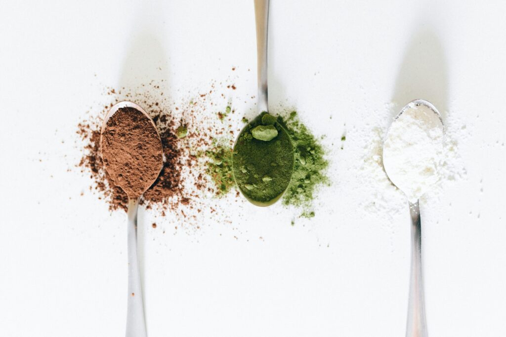 Kreatin ab 40 – drei Löffel mit Protein- und Superfood-Pulvern in Braun, Grün und Weiß für Muskelkraft, Regeneration und Langlebigkeit