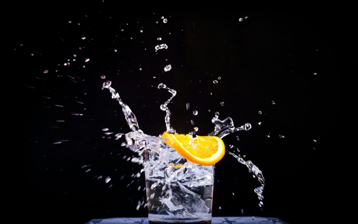 Wasserglas mit Zitrusscheibe beim Splash – Sinnbild für Hydratation und Flüssigkeitszufuhr im Sport